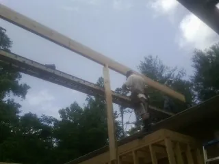 Carpenter setting a ridge beam over a new addition frame — Ice Dam Removal by Roofing Brothers in Melrose Park
