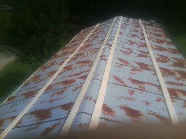 Rusted metal roof panels with new wood purlins before replacement — Storm Damage Roof Repair in Melrose Park by Roofing Brothers