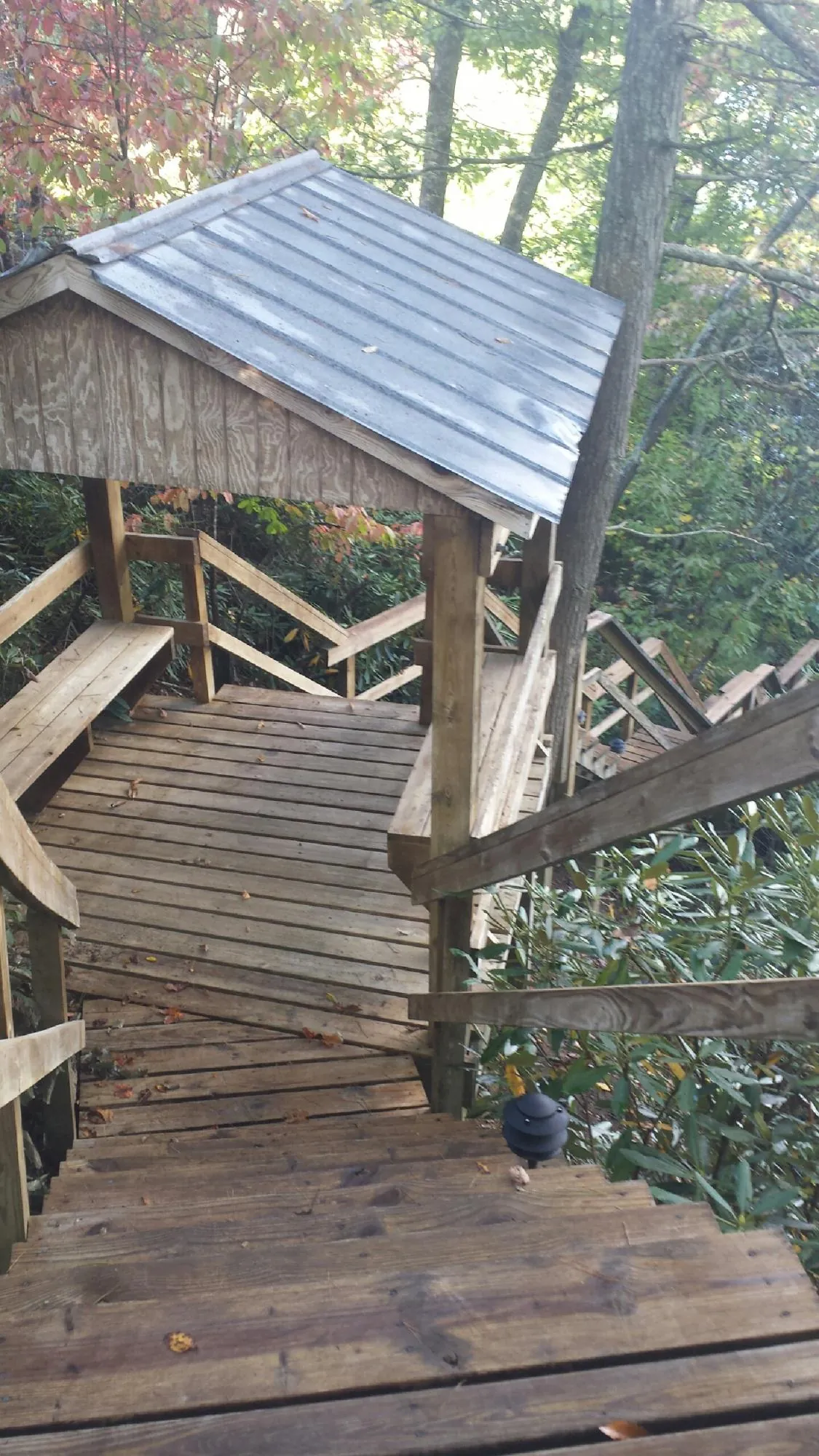 Metal roofed shelter over wooden steps on a wooded walkway — Skylight Repair & Installation work by our crew in Melrose Park