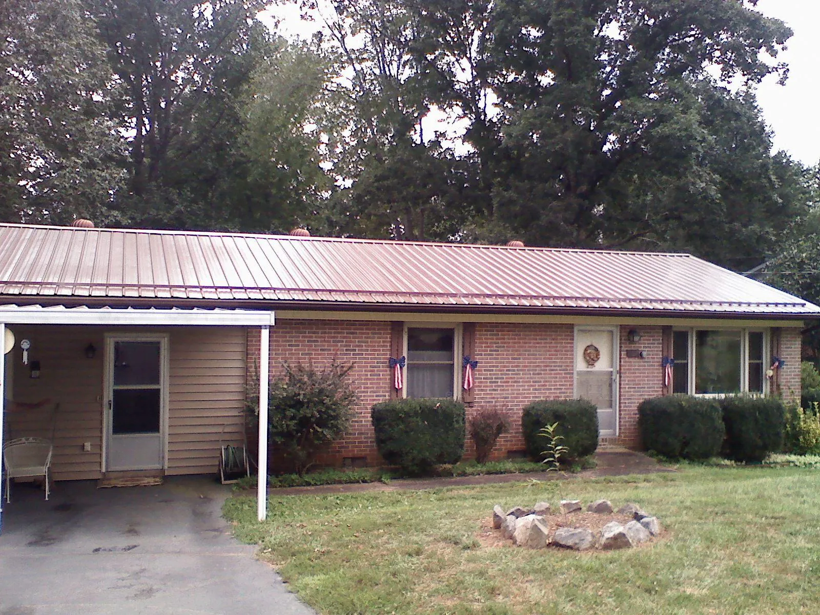 Bronze metal roof and carport on a brick ranch home — Roof Repair work by our crew in Melrose Park