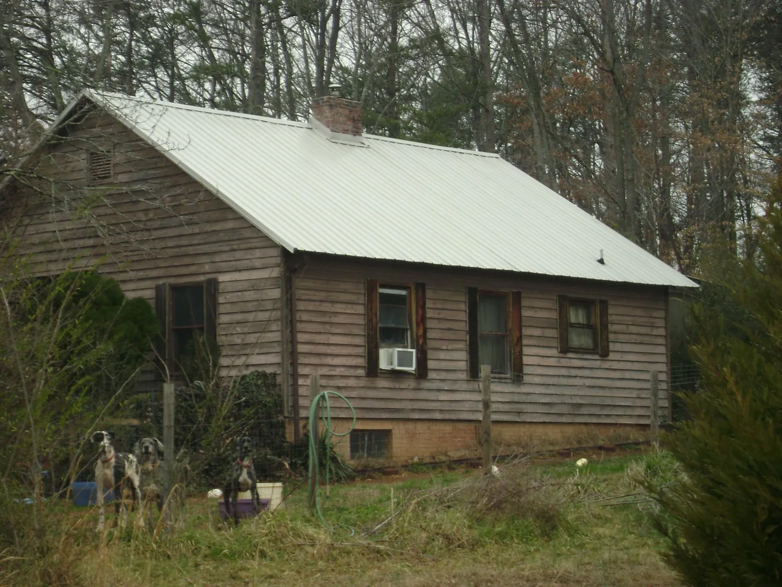 White metal roof on an old wood sided farmhouse, from a Metal Roof Installation job in Melrose Park